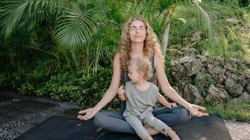 Alt-txt: woman doing yoga pose on a beach