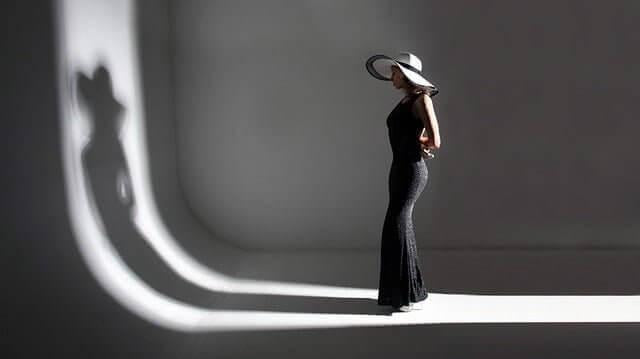 ALT TXT IMG: woman wearing a long black dress wearing a hat