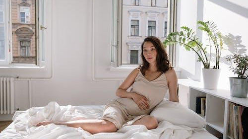 Alt Text: Woman in bed wearing a nightgown