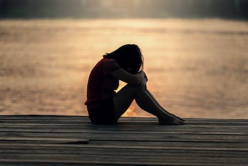 Woman sitting outside hunched over