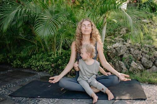 Alt-txt: woman doing yoga pose on a beach