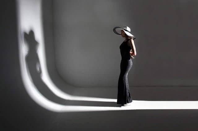 ALT TXT IMG: woman wearing a long black dress wearing a hat
